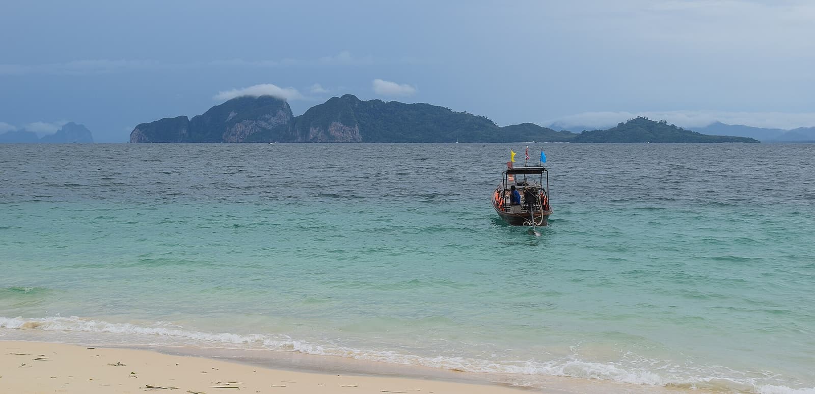 Koh Muk seen across turquoise water from the beach on Koh Kradan
