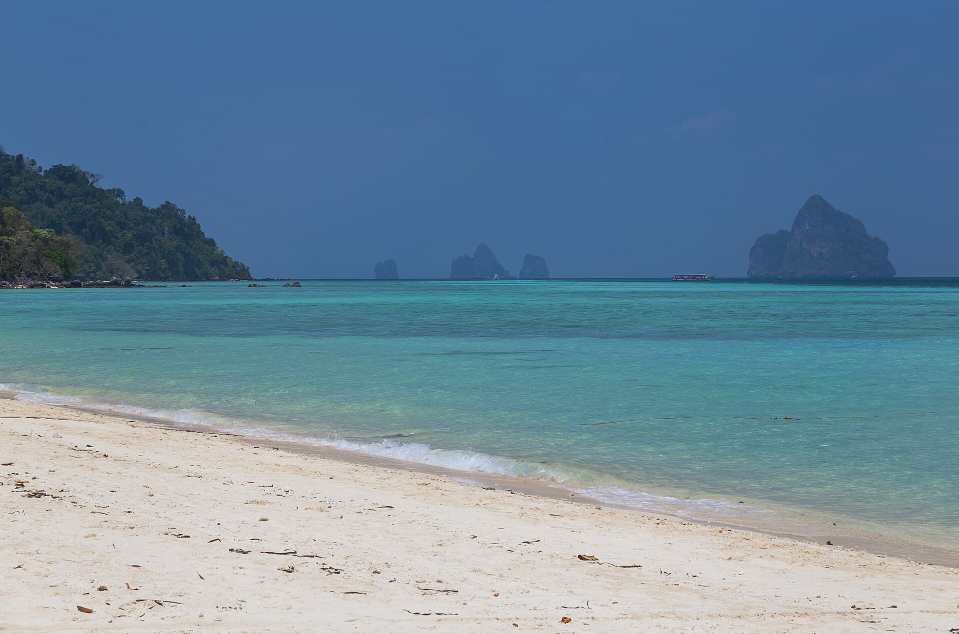 White sand and turquoise water on Koh Kradan, with limestone islands on the horizon