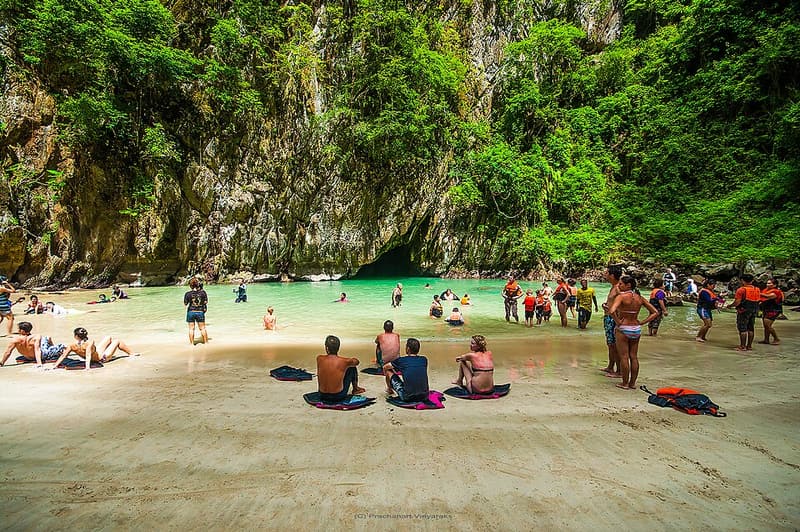 Swimmers on the small beach inside the Emerald Cave on Koh Muk