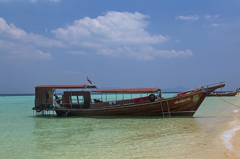 A longtail boat anchored in the clear water off Koh Kradan