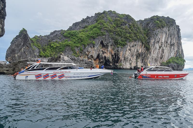 Speedboats anchored beside the limestone cliffs of Koh Chueak